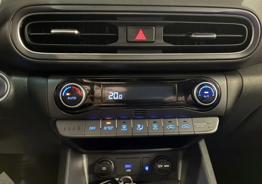 Tableau de bord noir du Hyundai Kona 2023, zoom sur commandes climatisation digitale et ventilation centrale.