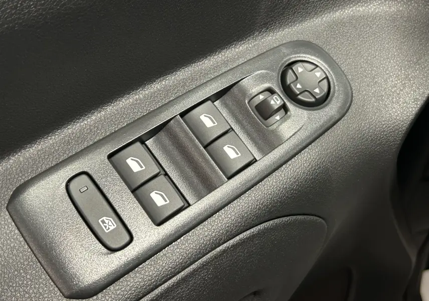 Gros plan sur les commandes électriques des vitres et des rétroviseurs côté conducteur du Citroën Berlingo Multispace gris Artense.