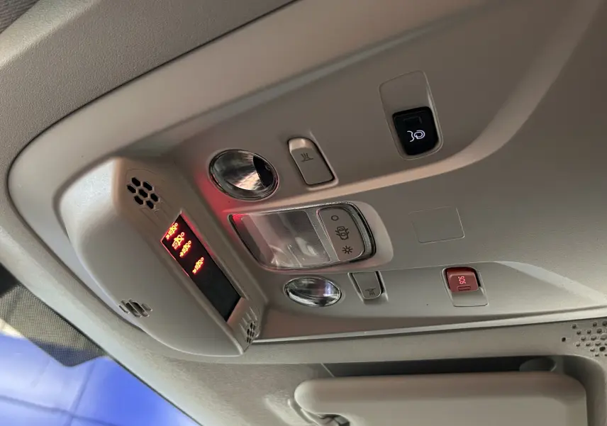 Plafonnier intérieur gris clair du Citroën Berlingo Multispace 2025 avec commandes d'éclairage et bouton SOS rouge.