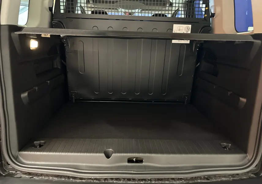 Coffre ouvert du Citroën Berlingo Multispace gris Artense, vue de l'arrière montrant l'espace de chargement et la cloison de séparation.
