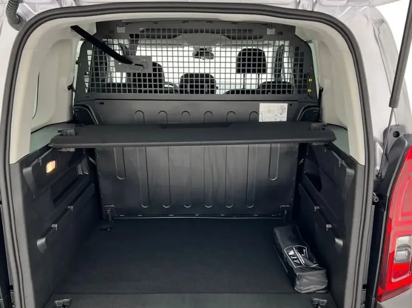 Coffre ouvert d’un Citroën Berlingo Multispace gris Artense, montrant la cloison de séparation et l’espace de chargement vide.