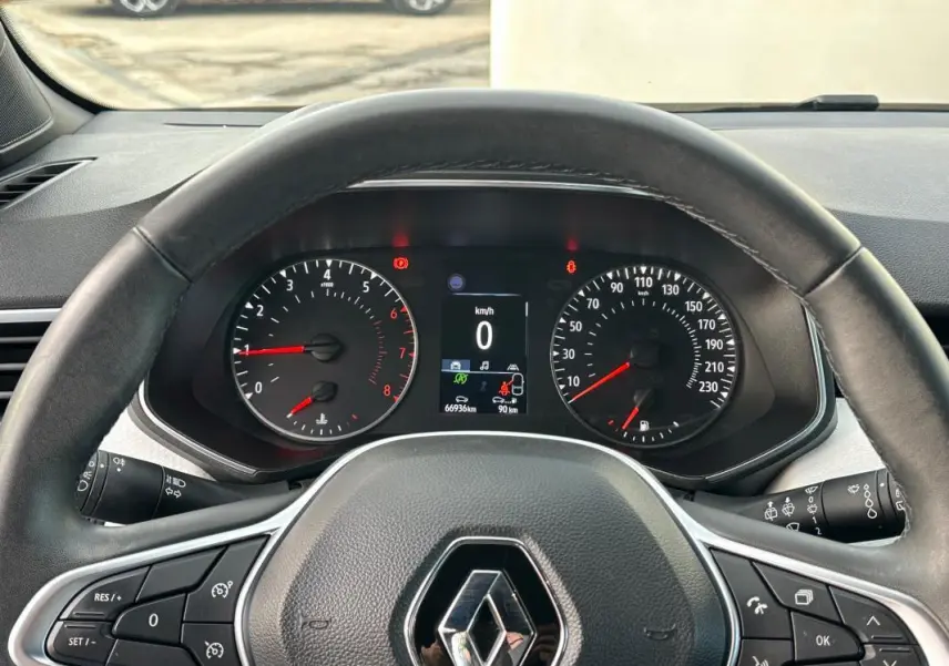 Vue intérieure du tableau de bord et volant de la Renault Clio V SCe 65 noir, avec affichage numérique et commandes au volant.