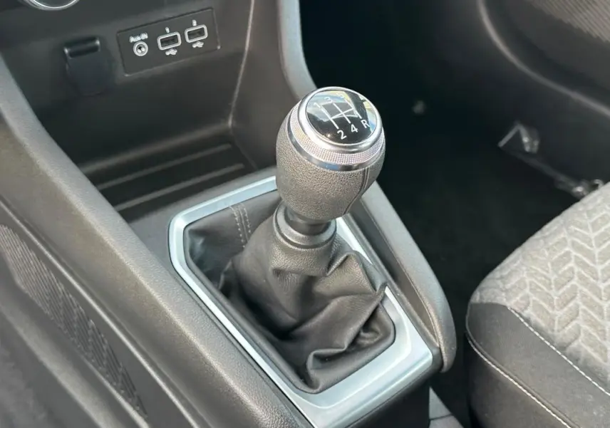 Le levier de vitesse manuel de la Renault Clio V SCe 65 21 Limited, entouré de garnitures noires et argentées.