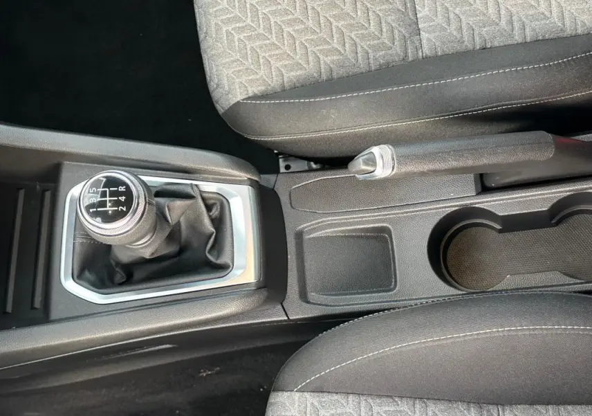 Vue rapprochée de la console centrale de la Renault Clio noire 2021, avec levier de vitesse manuel et frein à main.