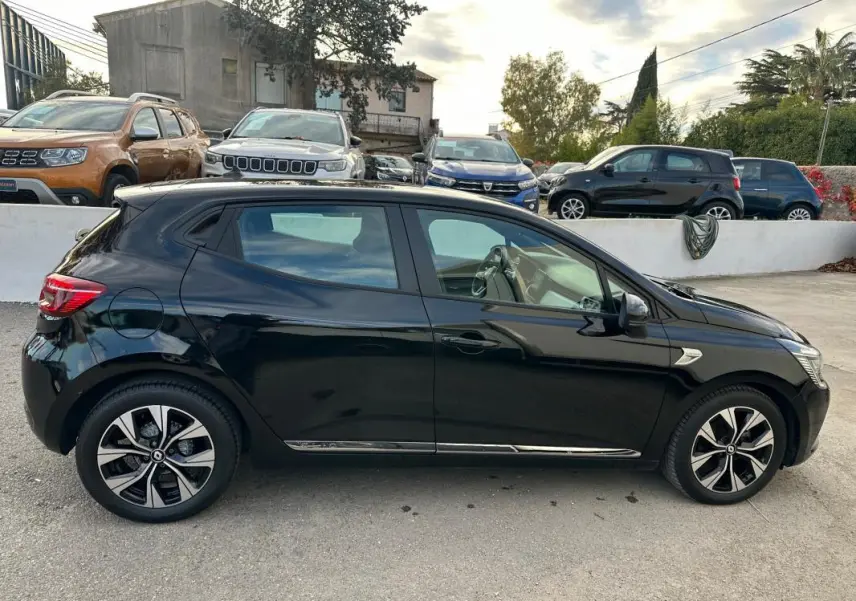 Profil côté gauche d'une Renault Clio V noire de 2021 avec jantes alliage 16 pouces, garée en extérieur.