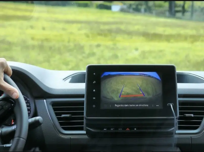 Vue intérieure du tableau de bord du Renault Trafic Fourgon 2025 avec écran de caméra de recul affichant un champ vert.