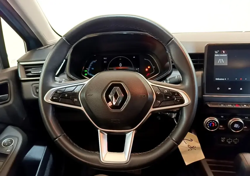 Vue centrée sur le volant cuir de la Renault Clio Business E-Tech hybride 2021 avec tableau de bord numérique et écran tactile.