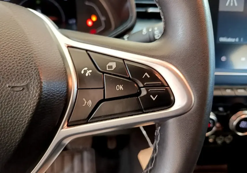 Gros plan sur les commandes multifonctions à droite du volant cuir noir de la Renault Clio Business E-Tech hybride 2021.