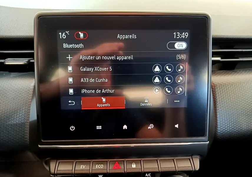 Écran tactile central affichant la connexion Bluetooth dans l’habitacle de la Renault Clio Business E-Tech hybride bleu, vue de face.