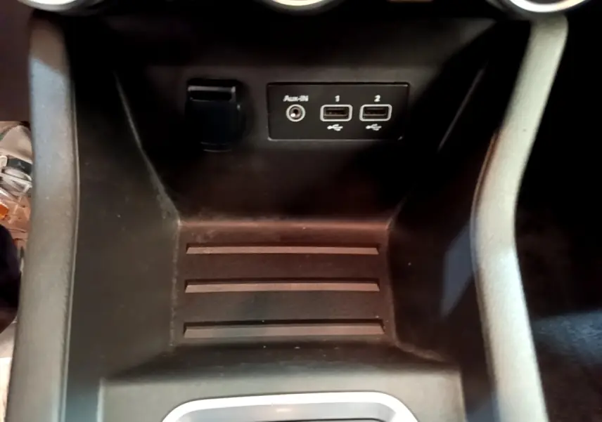 Vue rapprochée de la console centrale noire de la Renault Clio Business E-Tech hybride, avec ports USB et prise auxiliaire.