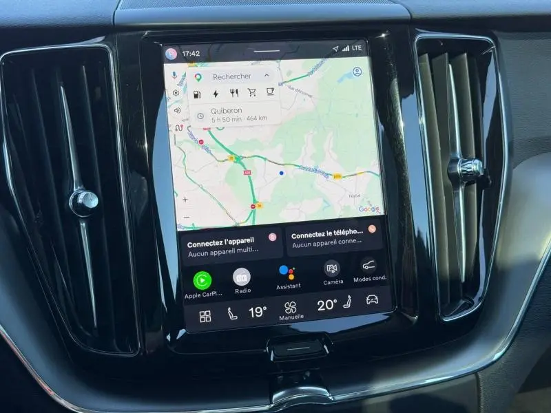 Écran tactile central du Volvo XC60 2024 gris, affichant la navigation avec commandes et aérateurs verticaux noirs.