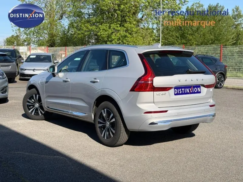 Vue 3/4 arrière droite d'un Volvo XC60 gris avec feux arrière LED en forme de L et jantes alliage.