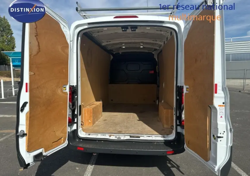 Vue arrière du Ford Transit Fourgon blanc 2015 avec portes ouvertes montrant l’espace de chargement vide et doublure boisée.