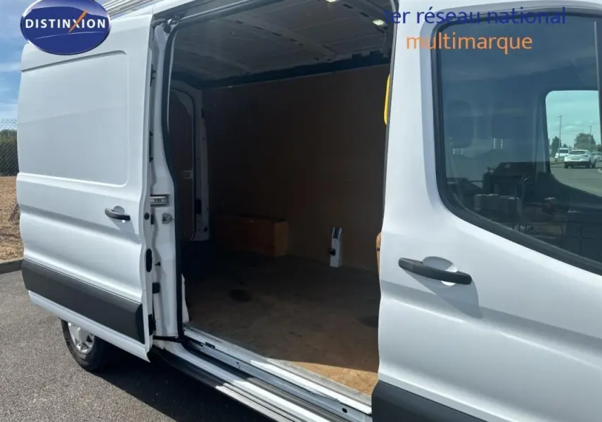 Vue latérale gauche d’un Ford Transit Fourgon blanc 2015 avec porte coulissante ouverte montrant l’espace de chargement.