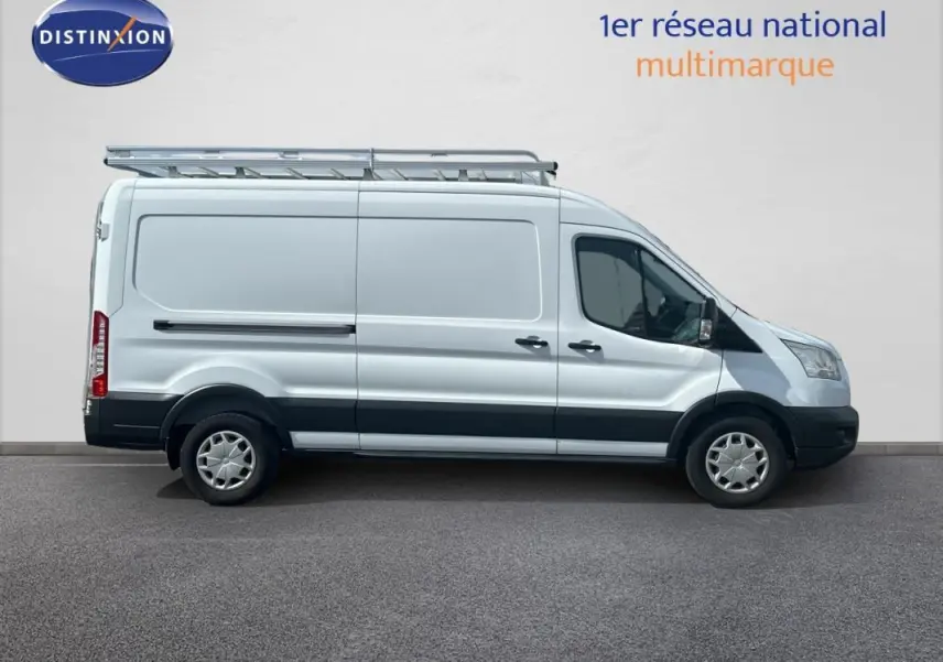 Ford Transit Fourgon blanc en profil droit avec galerie de toit et jantes classiques 16 pouces.