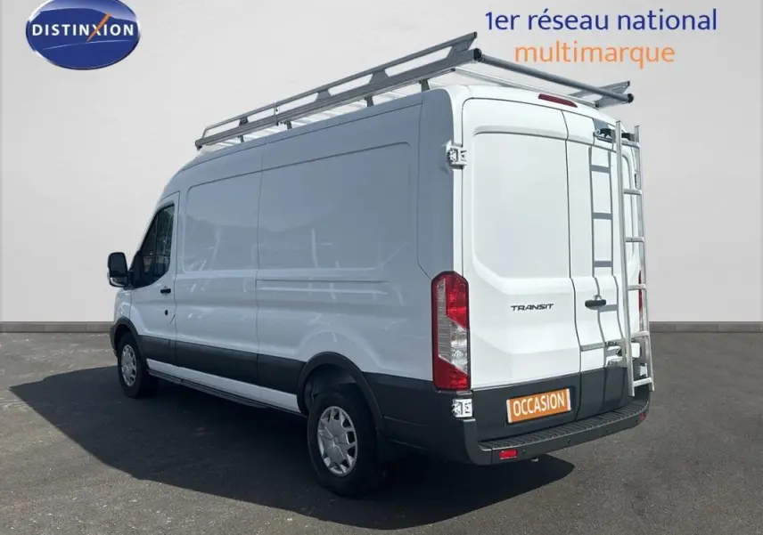 Vue 3/4 arrière droite d’un Ford Transit Fourgon blanc avec galerie et échelle sur porte arrière.