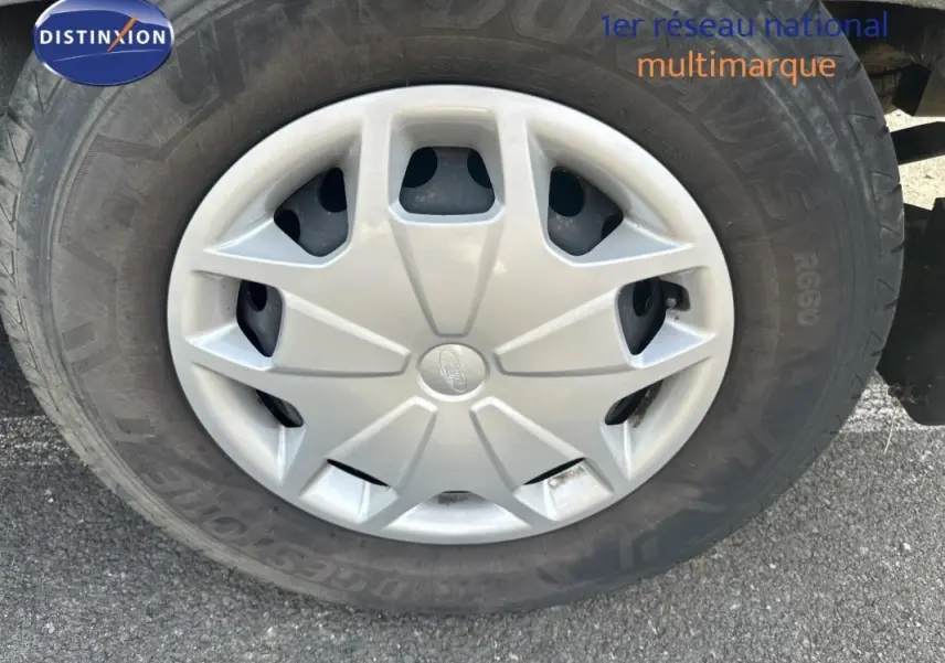 Gros plan sur la jante classique 16 pouces d'un Ford Transit Fourgon blanc, avec logo Ford au centre.