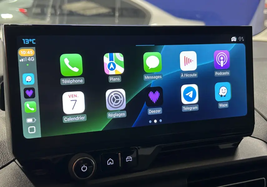 Écran tactile central affichant Apple CarPlay dans l'habitacle du Citroën Berlingo Multispace gris, vue de face.