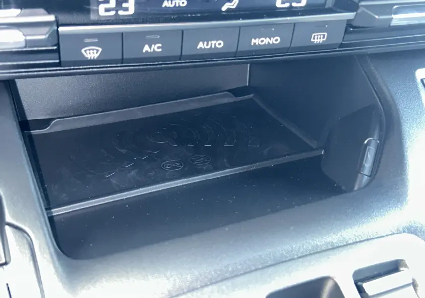 Gros plan sur la console centrale du Citroën Berlingo Multispace 2025, montrant le plateau de recharge sans fil et commandes climatisation.
