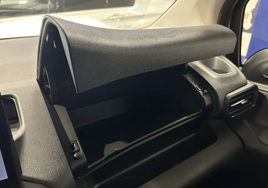 Intérieur du Citroën Berlingo Multispace 2025 gris Artense, vue sur la boîte à gants ouverte côté passager.