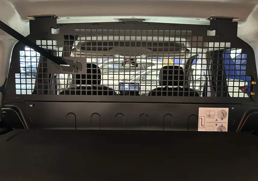 Vue intérieure arrière du Citroën Berlingo Multispace gris Artense, montrant la grille de séparation et les sièges avant.