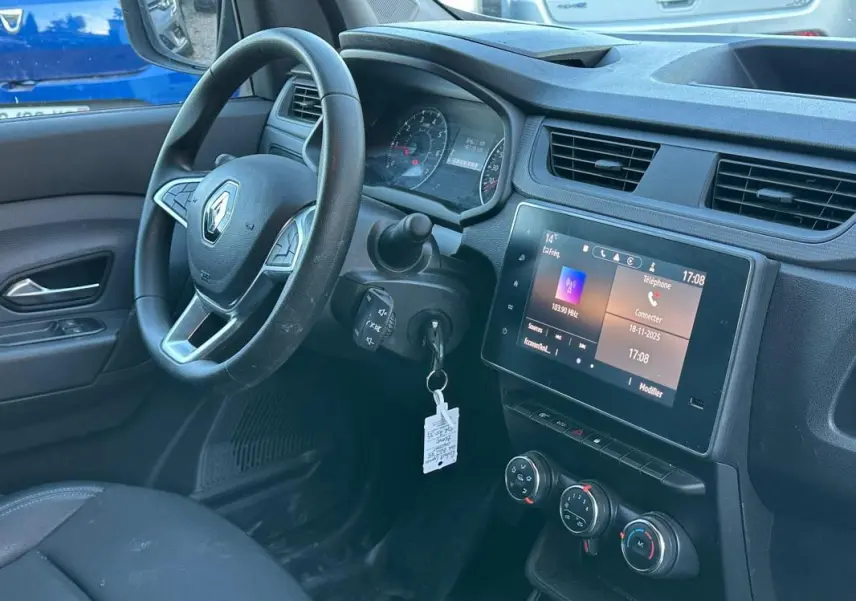 Vue intérieure côté conducteur du tableau de bord et volant Renault Express Van blanc 2023 avec écran tactile et commandes climatisation.