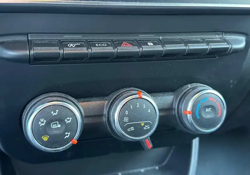 Gros plan sur les commandes de climatisation et boutons fonctionnels du tableau de bord du Renault Express Van blanc 2023.