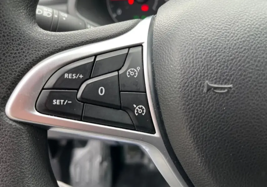 Détail du volant côté gauche du Renault Express Van blanc 2023, montrant les commandes du régulateur de vitesse.