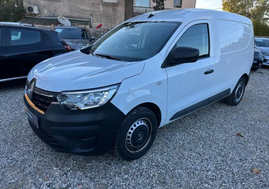 Renault Express Van blanc vu en 3/4 avant droit, avec pare-chocs noir et jantes acier simples sur un sol gravillonné.