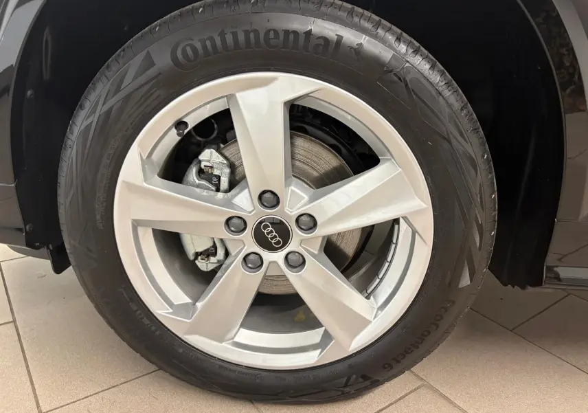 Gros plan sur la roue avant droite d’un Audi Q2 Noir Mythic avec jante alliage et pneu Continental.