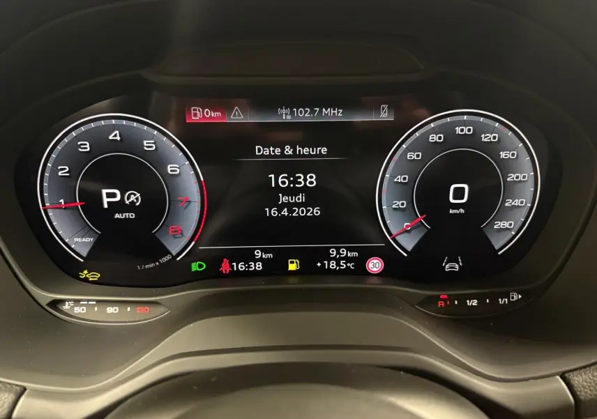 Vue rapprochée du tableau de bord numérique de l'Audi Q2 35 TFSI 2026 affichant la date, l'heure et les compteurs en mode automatique.