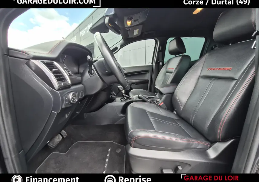 Vue intérieure côté conducteur du Ford Ranger Thunder 2020, sièges cuir noirs avec surpiqûres rouges et logo Thunder.