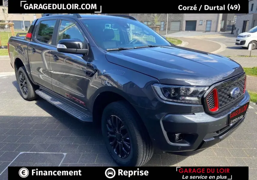 Ford Ranger gris foncé en 3/4 avant droit, avec calandre noire et détails rouges distinctifs Thunder.