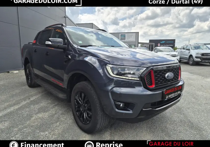 Vue 3/4 avant d'un Ford Ranger Thunder gris foncé avec calandre noire et inserts rouges, roues noires et marchepieds latéraux.