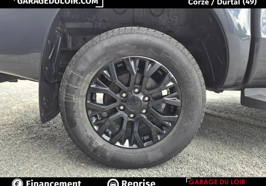 Gros plan sur la roue avant gauche noire du Ford Ranger gris foncé, mettant en valeur la jante en alliage et le pneu Continental.