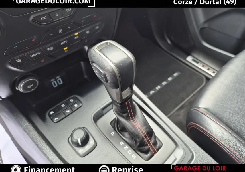 Gros plan sur la console centrale du Ford Ranger gris foncé, mettant en valeur le levier de vitesse automatique avec surpiqûres rouges.