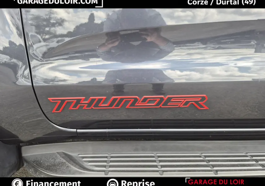 Gros plan sur l’inscription rouge Thunder sur la porte latérale grise foncée du Ford Ranger 2020 avec marchepied visible.