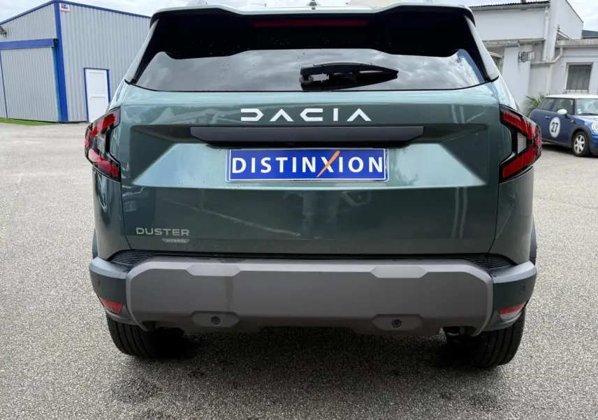 Vue arrière du Dacia Duster Hybrid 140 Journey vert cèdre avec logo DACIA et feux arrière LED distinctifs.