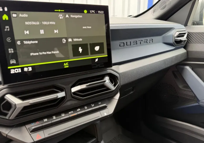 Vue intérieure côté passager du tableau de bord du Dacia Duster avec écran tactile et inscription DUSTER en relief.