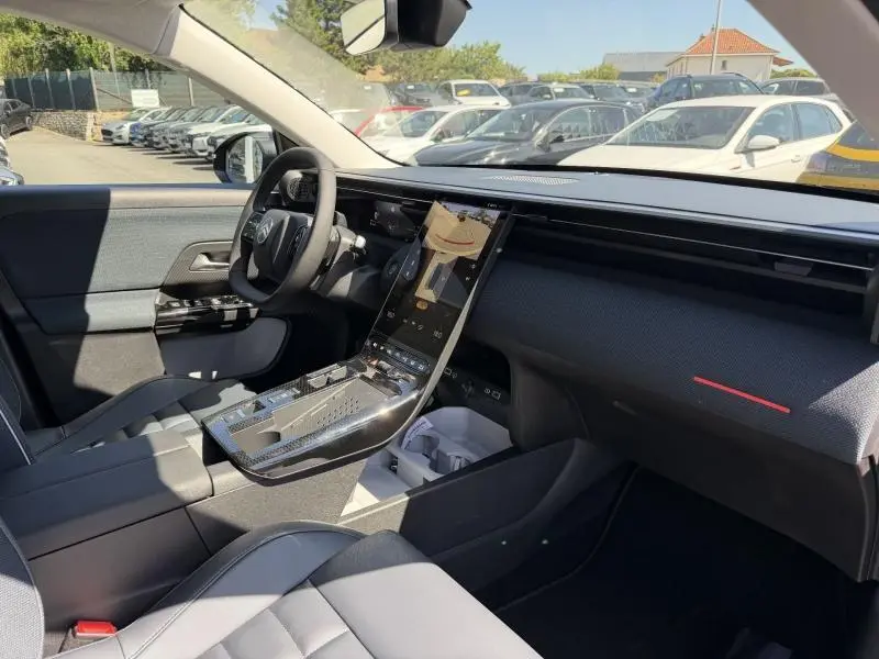Intérieur avant droit du Citroën C5 Aircross 2026, tableau de bord noir avec écran tactile vertical et sellerie tissu bleu.