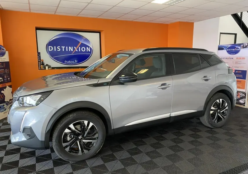 Peugeot 2008 e-136 Allure Pack gris Artense en vue profil droit, jantes alliage noires et toit noir en showroom.