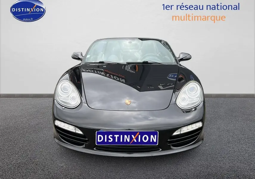 Vue frontale d'une Porsche Boxster 987 noire avec phares bi-xénon et feux LED, sur fond neutre.