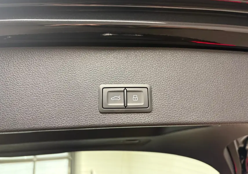 Gros plan sur les boutons du hayon électrique de l'Audi Q2 35 TFSI S Line noir Mythic, vue intérieure arrière.