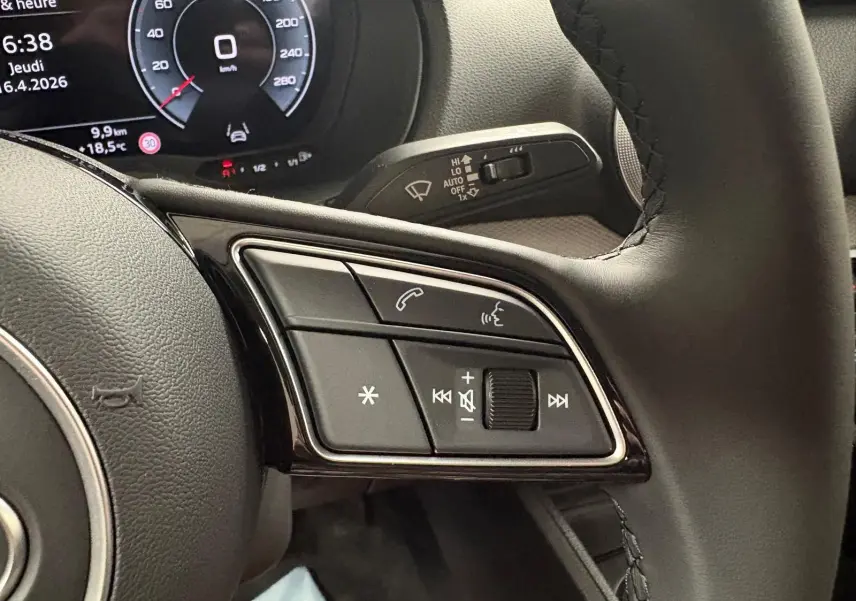 Gros plan sur les commandes au volant d’un Audi Q2 35 TFSI S line 2026 avec tableau de bord numérique.