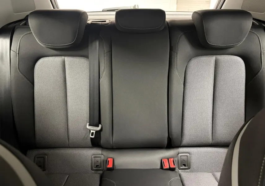 Vue arrière des sièges arrière en tissu gris et noir de l'Audi Q2 35 TFSI S Line 2026, avec ceinture et appuie-têtes.