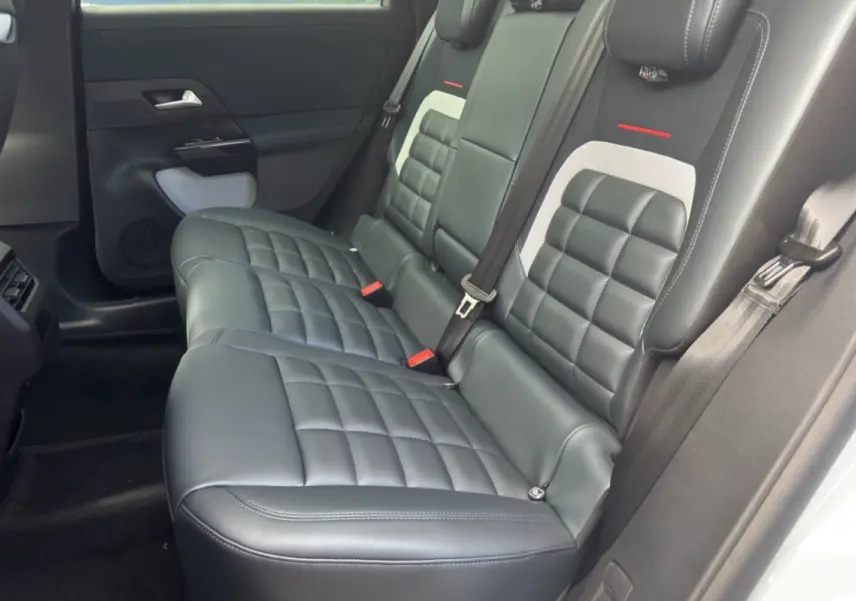 Vue latérale intérieure montrant la banquette arrière en cuir noir matelassé du Citroën C5 Aircross New Hybrid 2026.