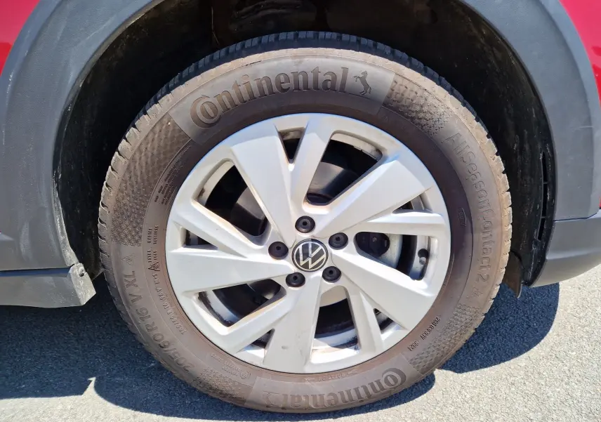 Gros plan sur la roue avant droite du Volkswagen Taigo rouge roi 2023 avec jante alliage et pneu Continental.