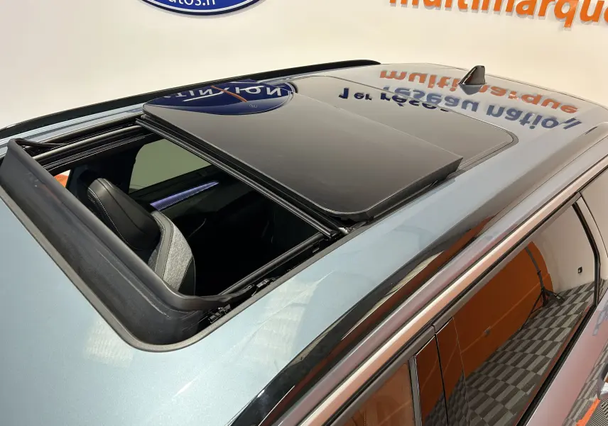 Vue en plongée du toit ouvrant panoramique ouvert sur le côté gauche d’un Peugeot 5008 Bleu Ingaro.