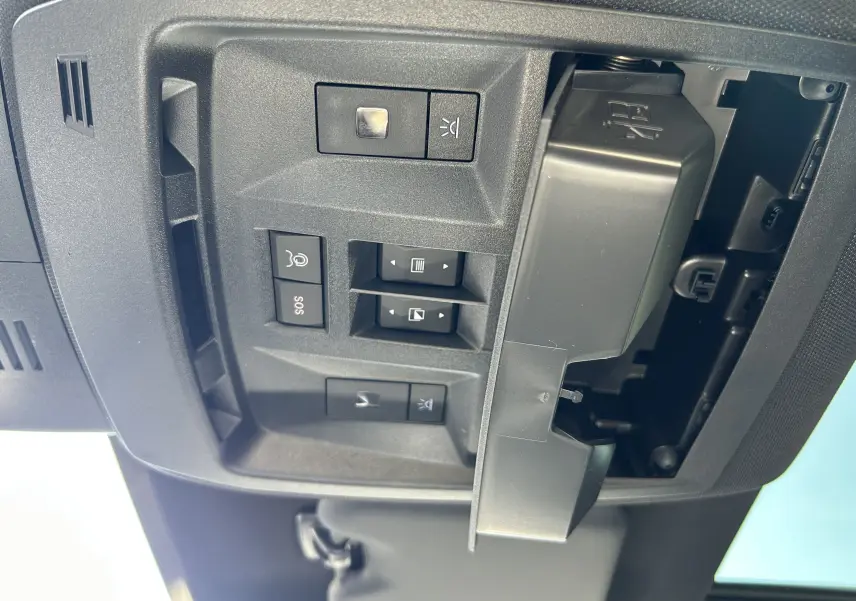 Vue en gros plan du panneau de commandes au plafond du Peugeot 5008 bleu Ingaro, avec boutons SOS et éclairage.