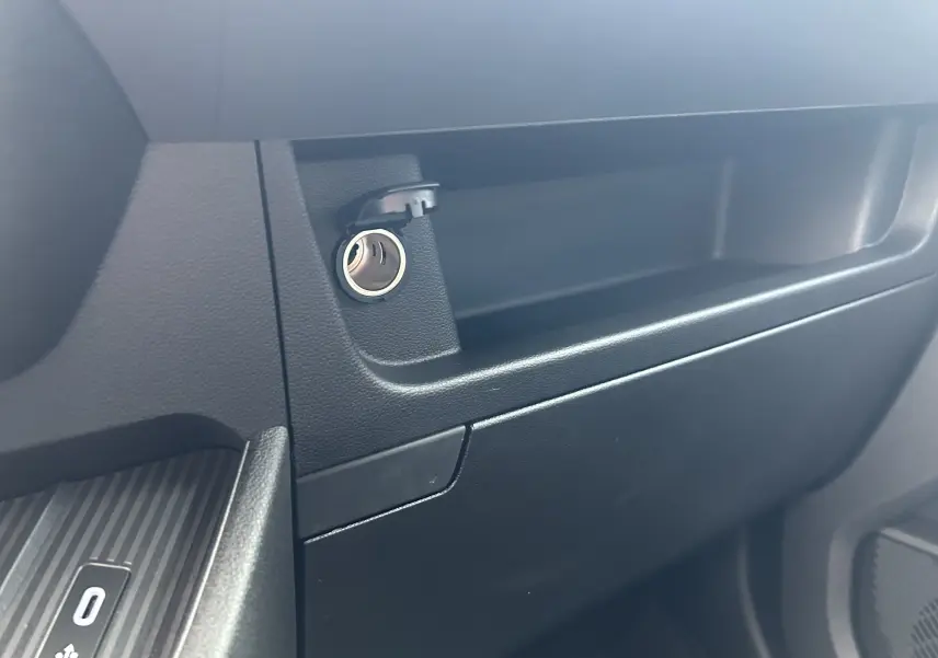 Détail de la prise 12V ouverte sur la planche de bord noire du Renault Master IV L2H2 Fourgon Advance 2025.
